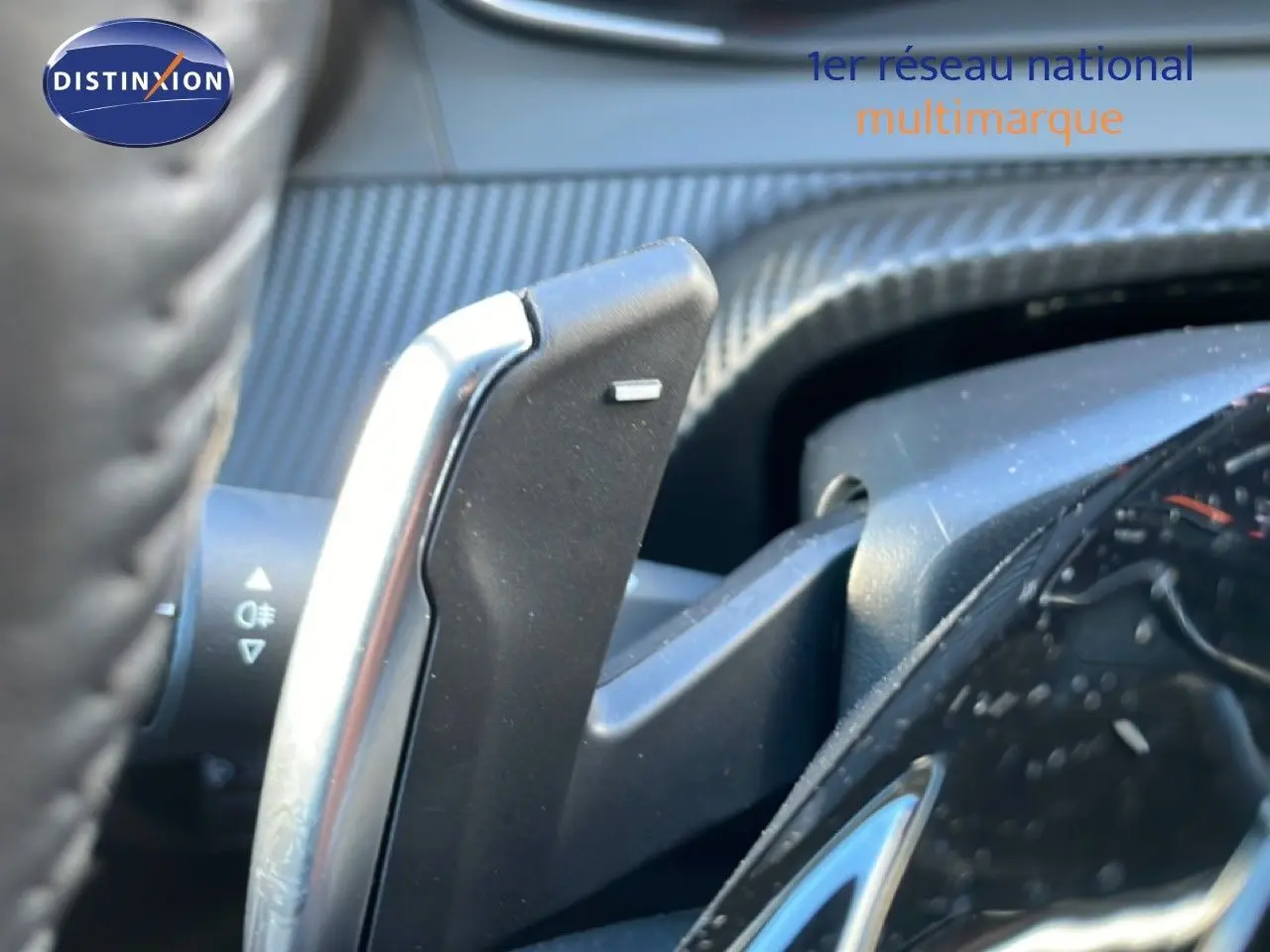 Gros plan sur la palette de changement de vitesse côté droit du volant d’une Peugeot 208 noire hybride 2025.