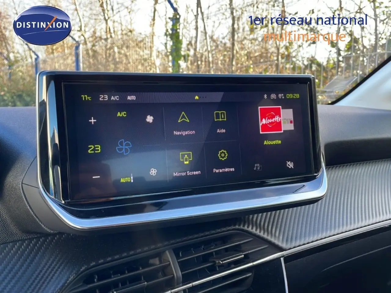 Écran tactile central affichant la climatisation et la navigation dans l'habitacle gris-noir d'une Peugeot 208 hybride.