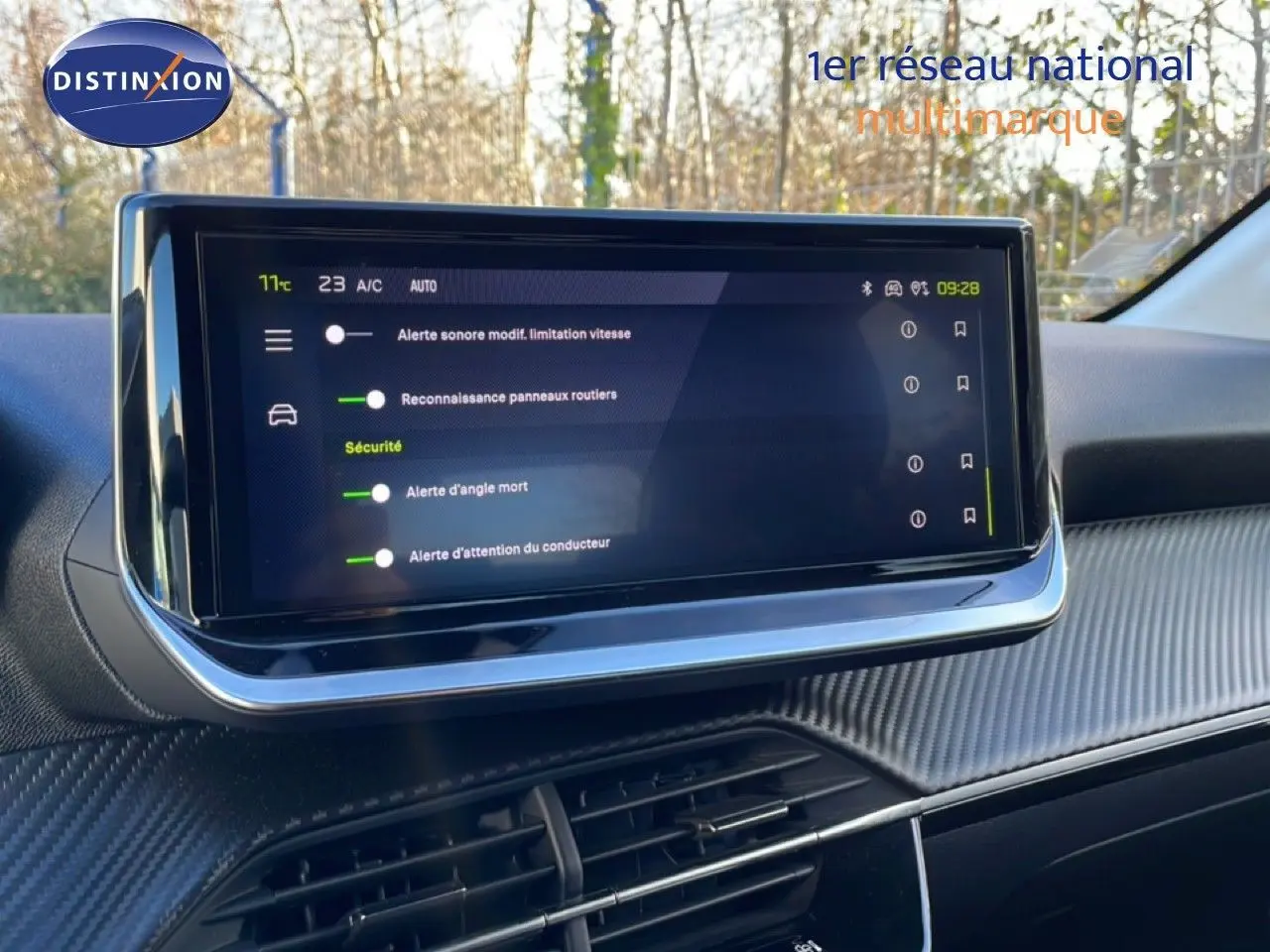 Écran tactile central en gros plan dans l’habitacle d’une Peugeot 208 noire, affichant les alertes de sécurité.