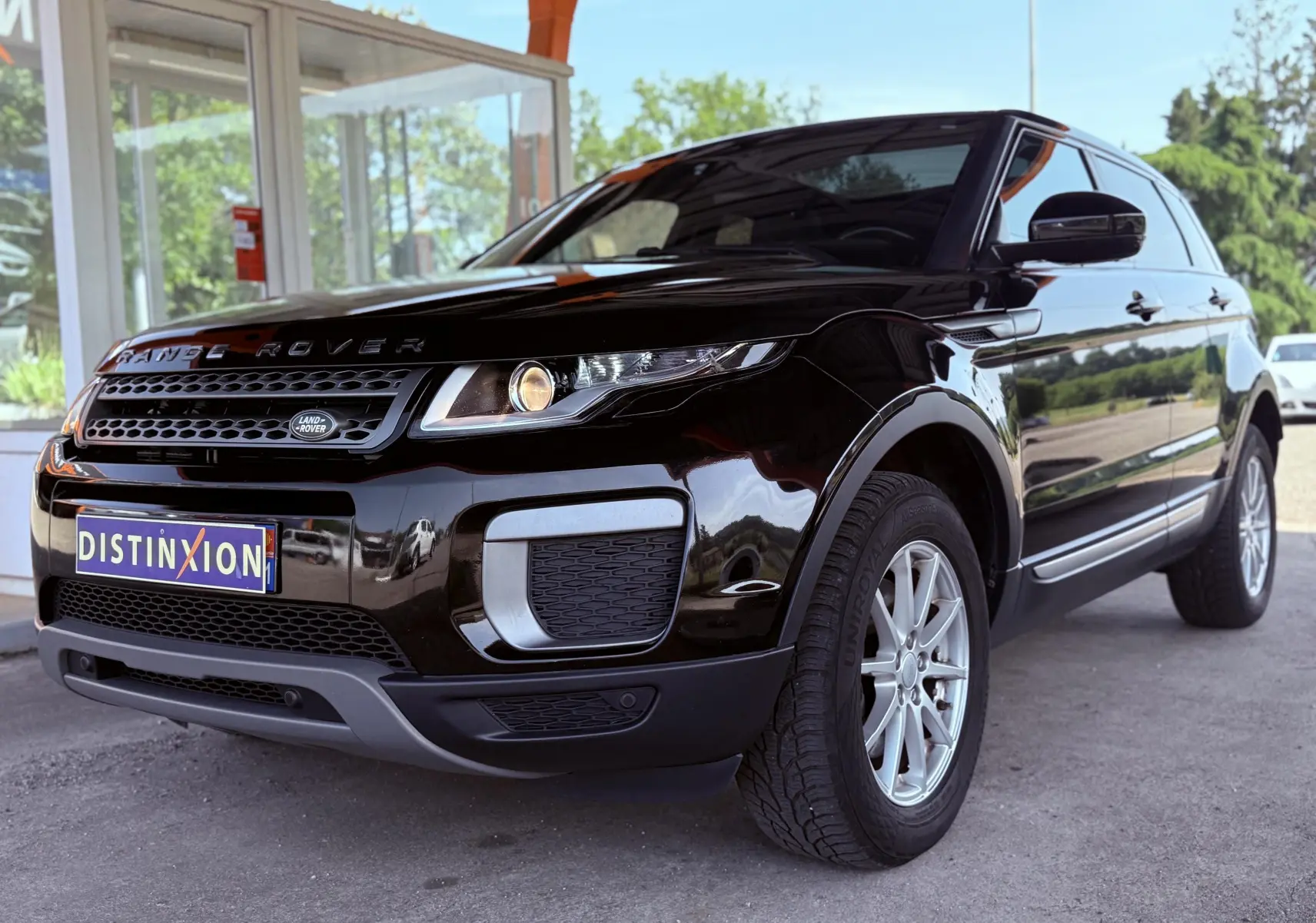 Vue 3/4 avant droit d'un Range Rover Evoque noir brillant avec calandre distinctive et jantes argentées.