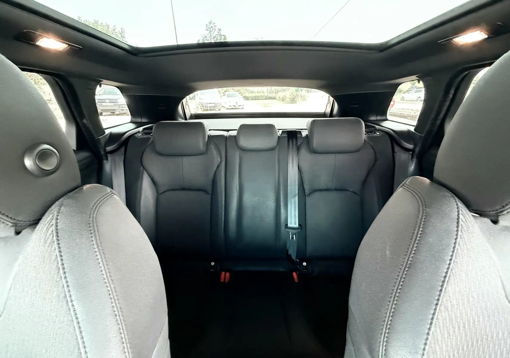 Vue intérieure arrière du Range Rover Evoque 2017 avec sièges en cuir noir et toit panoramique ouvert