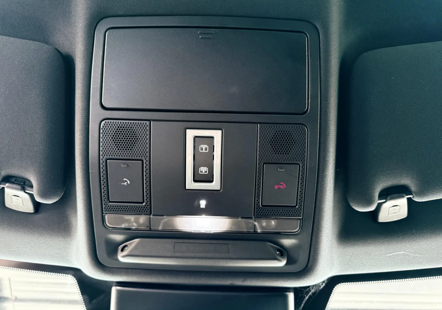 Vue en plongée sur la console de toit noire du Range Rover Evoque 2017 avec commandes d'éclairage et SOS.