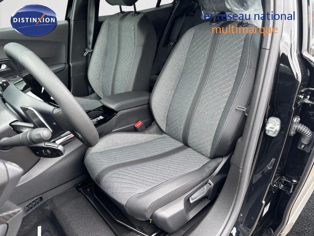 Vue intérieure côté conducteur du Peugeot 2008 Hybrid 136ch Allure 2025, sièges tissu gris et noir, portière noire ouverte.