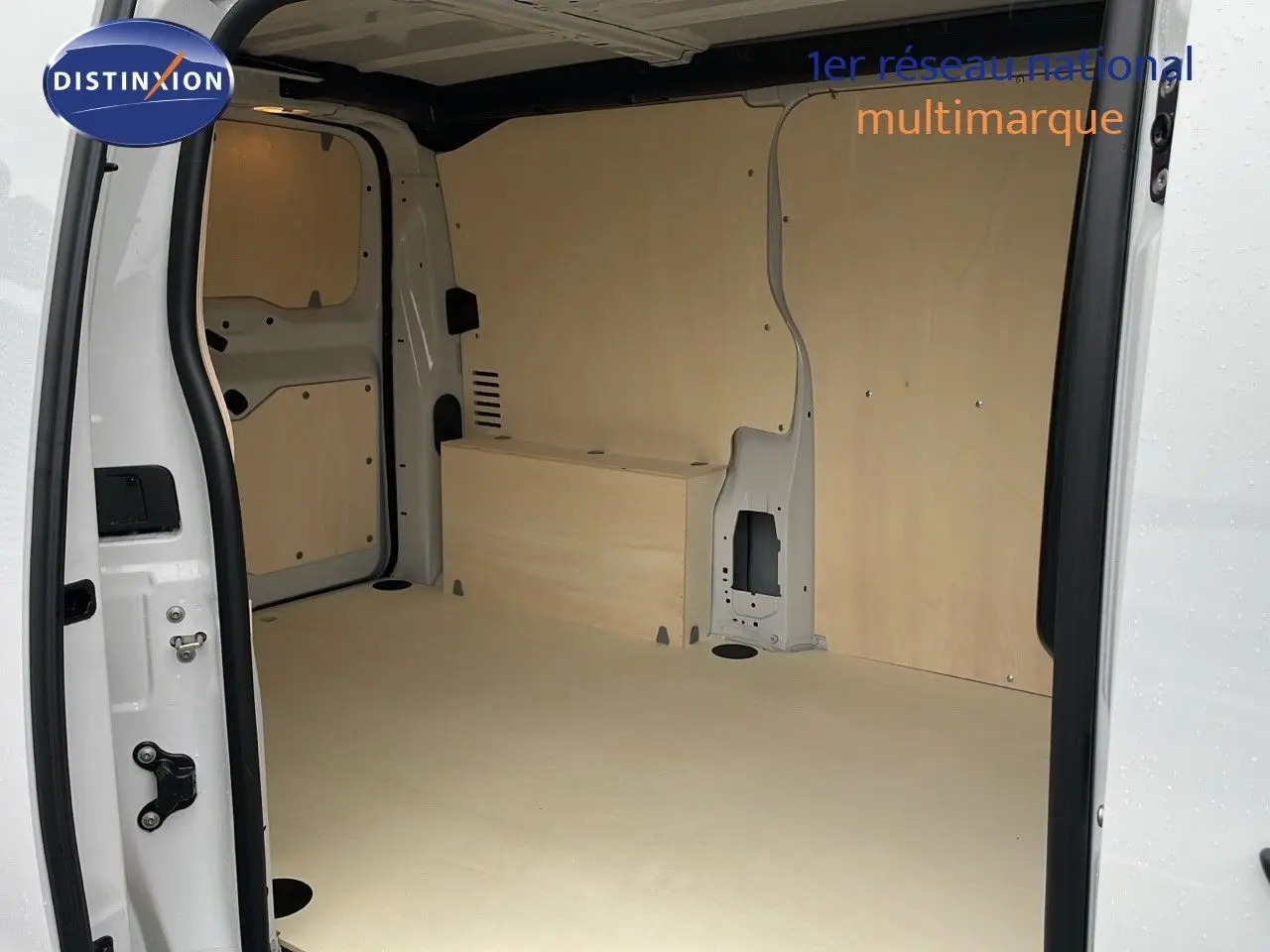 Vue intérieure arrière du Peugeot Expert Fourgon blanc 2025 montrant l'espace de chargement avec habillage bois clair.