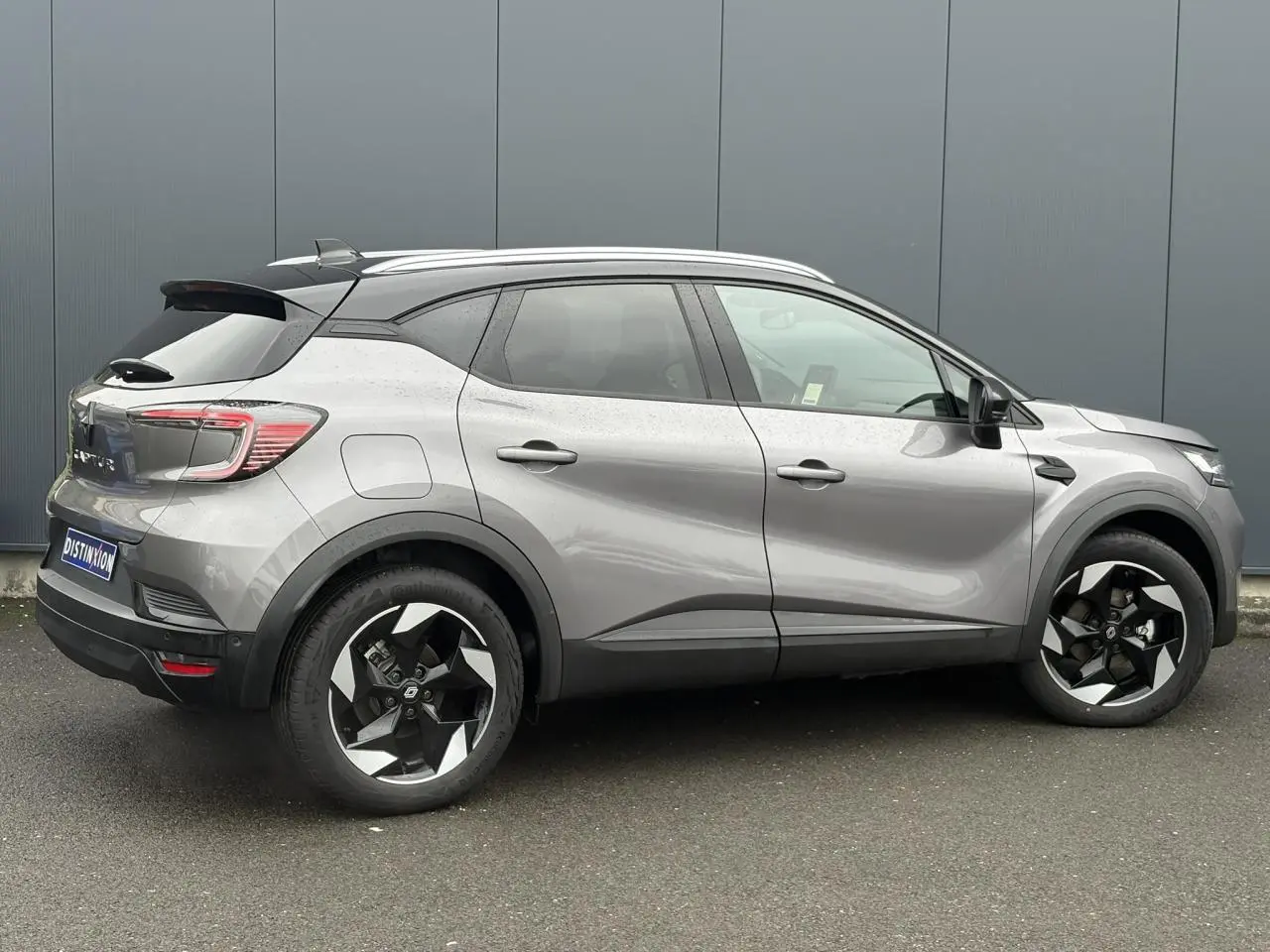 Renault Captur 2025 gris Cassiopée et noir, vue de profil côté droit, jantes alu 18" diamantées noires et railing toit alu.