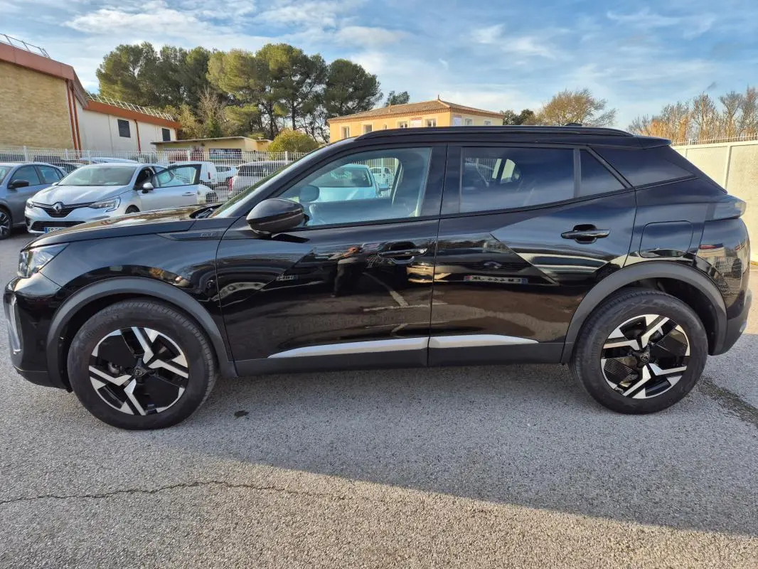 Vue latérale droite du Peugeot 2008 Hybrid 145 e-DCS6 GT noir avec jantes alliage 18 pouces et barres de toit.