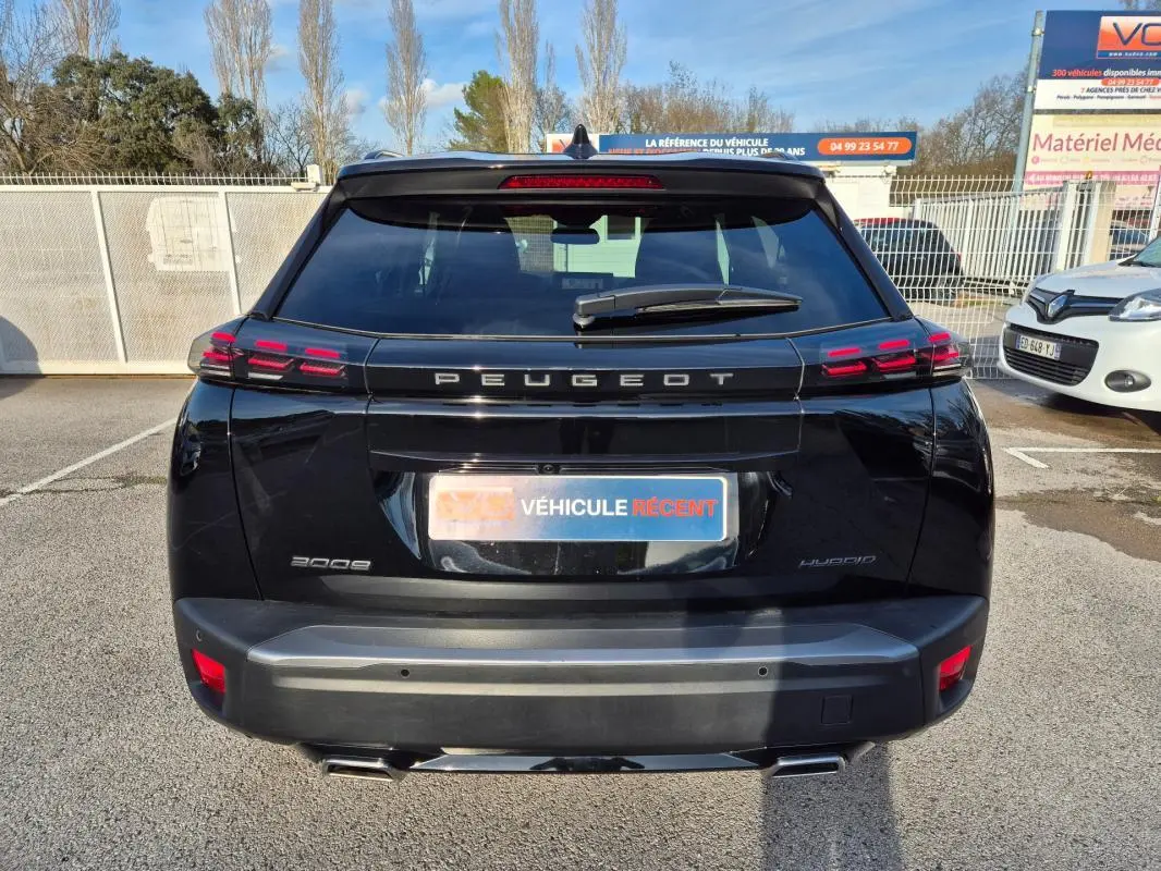 Vue arrière d’un Peugeot 2008 Hybrid 145 e-DCS6 GT noir, avec feux LED et double sortie d’échappement visible.