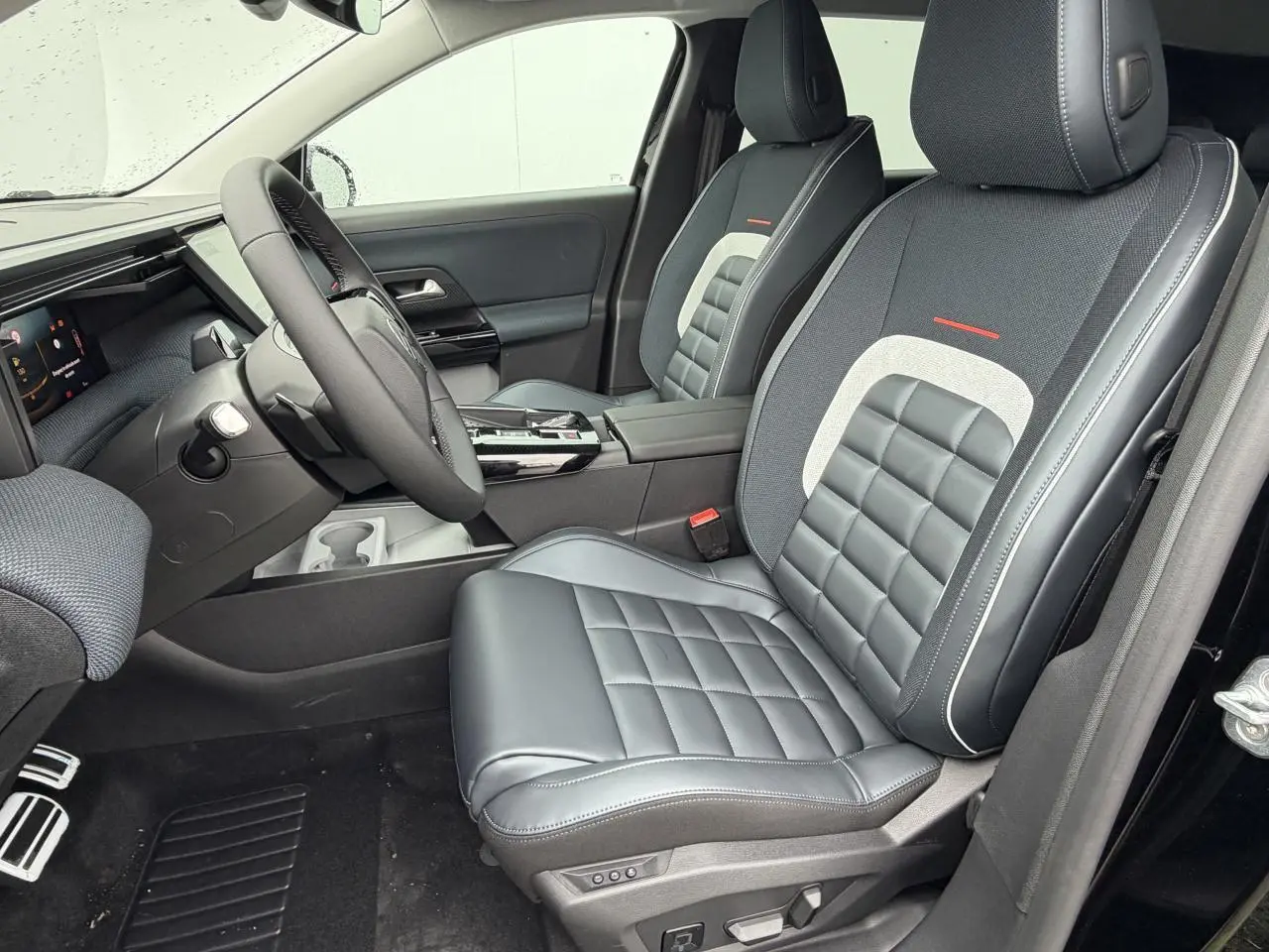 Vue intérieure côté conducteur du Citroën C5 Aircross 2026, sièges en cuir et tissu bleu avec surpiqûres blanches.