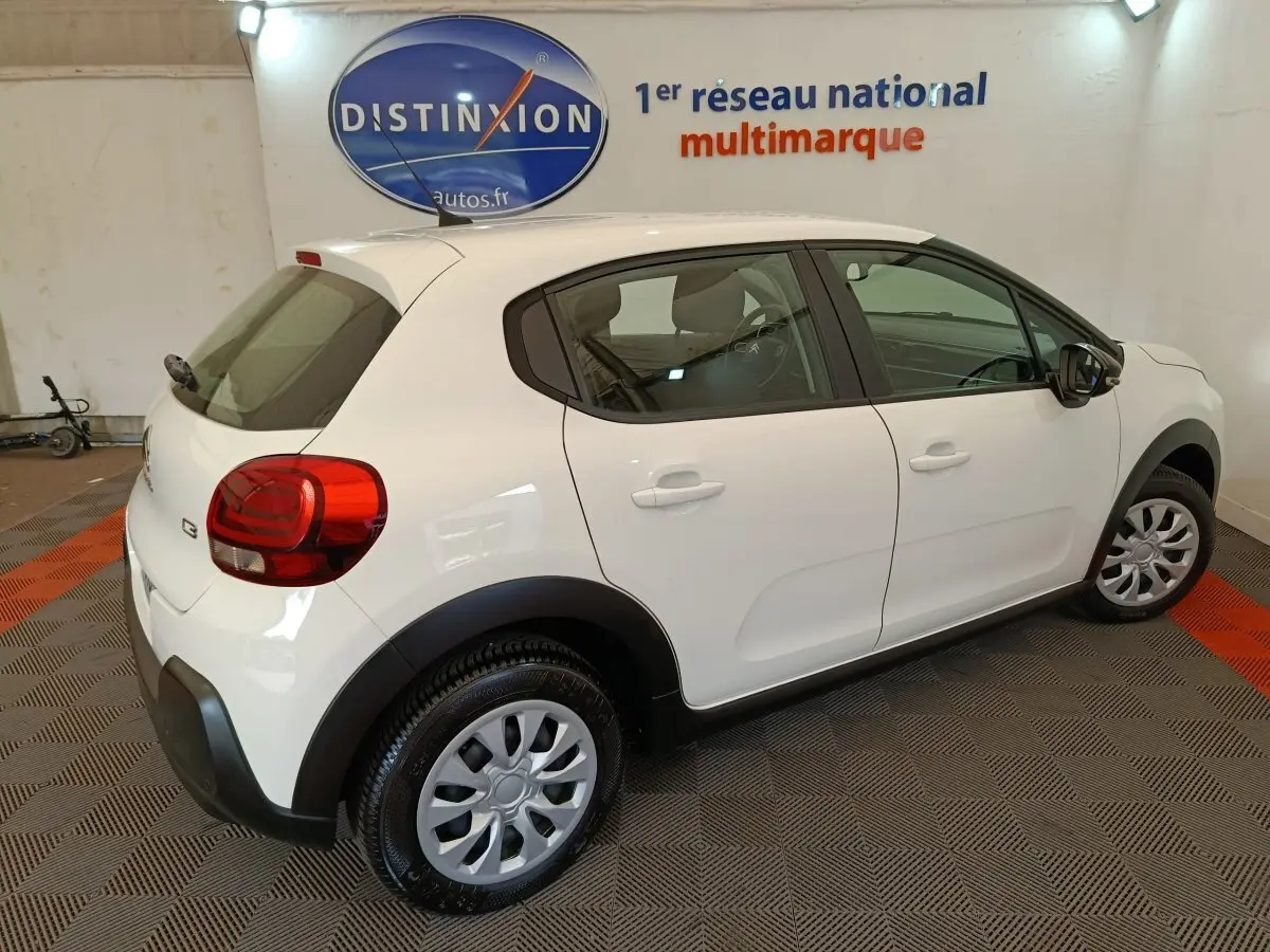 Vue 3/4 arrière droite d'une Citroën C3 blanche 2020 avec jantes acier et protections noires sur les passages de roues.
