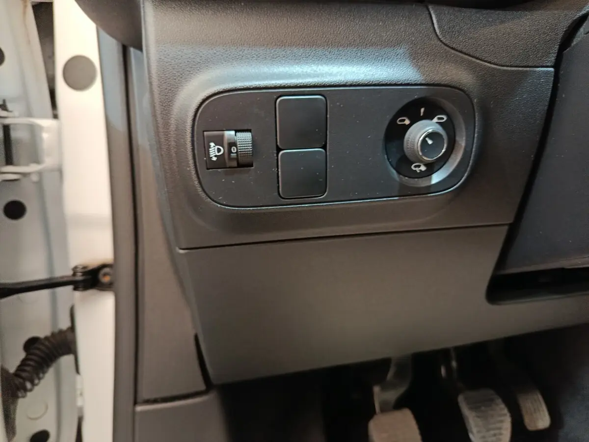Détail des commandes de réglage des phares et rétroviseurs côté conducteur d'une Citroën C3 blanche de 2020.