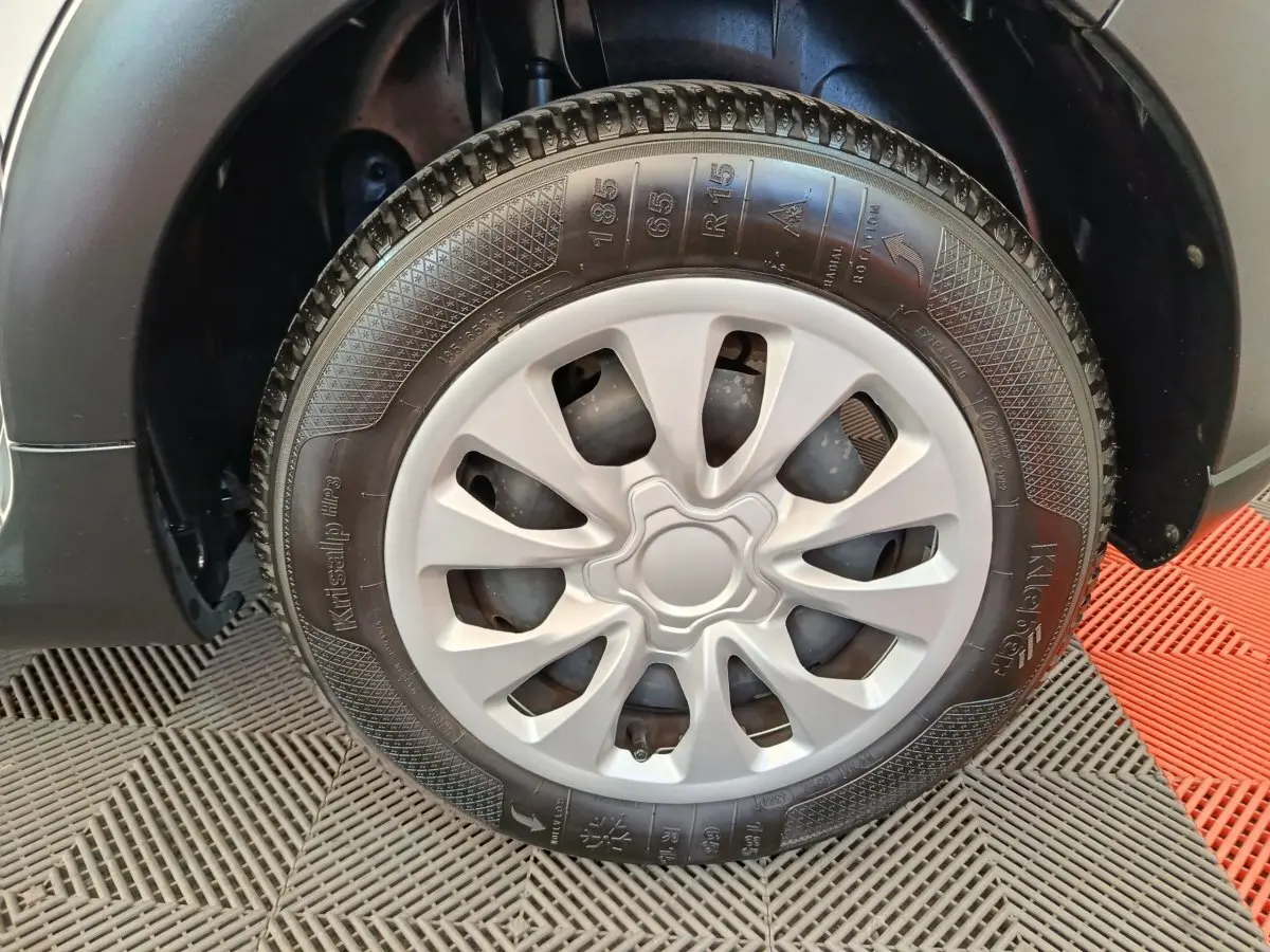 Gros plan sur la roue avant droite d'une Citroën C3 blanche, mettant en valeur la jante en plastique gris clair.