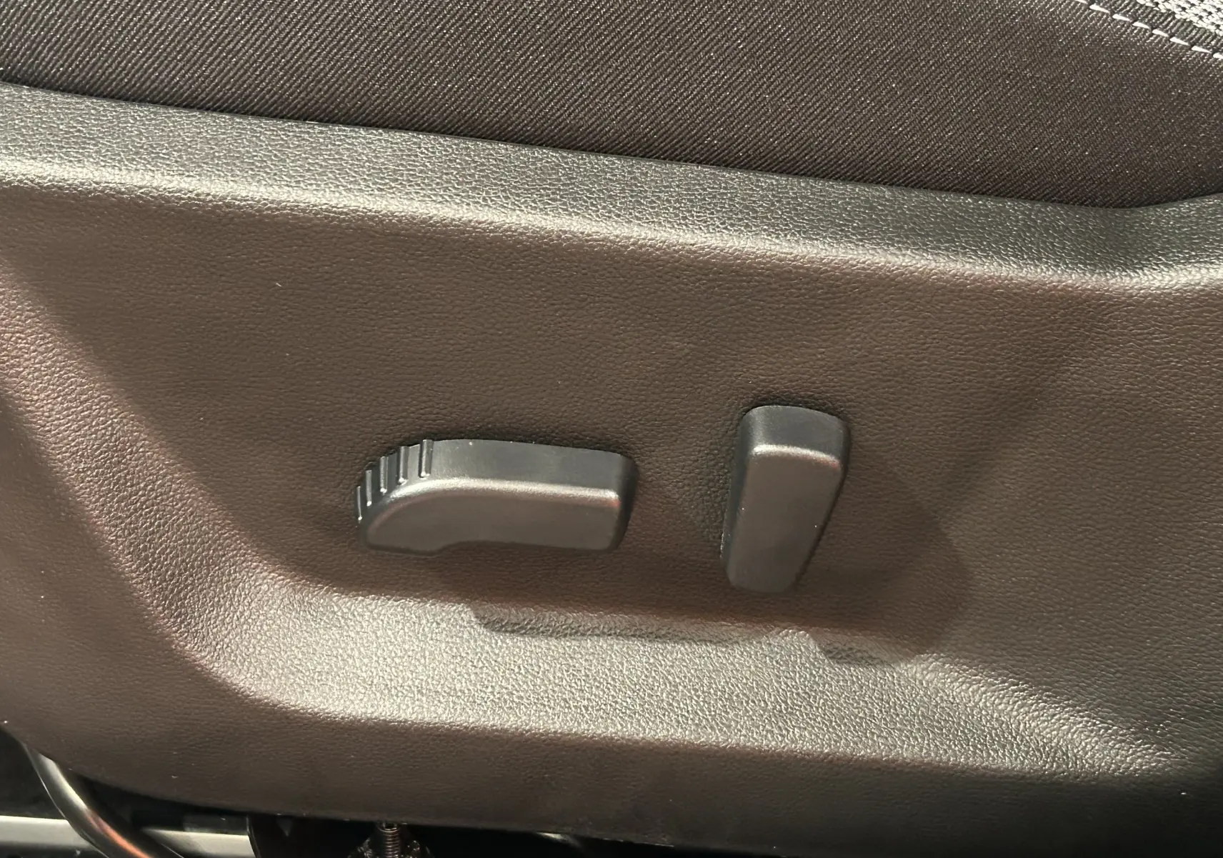 Gros plan sur les commandes de réglage électrique du siège avant en tissu du Dacia Bigster 2026.