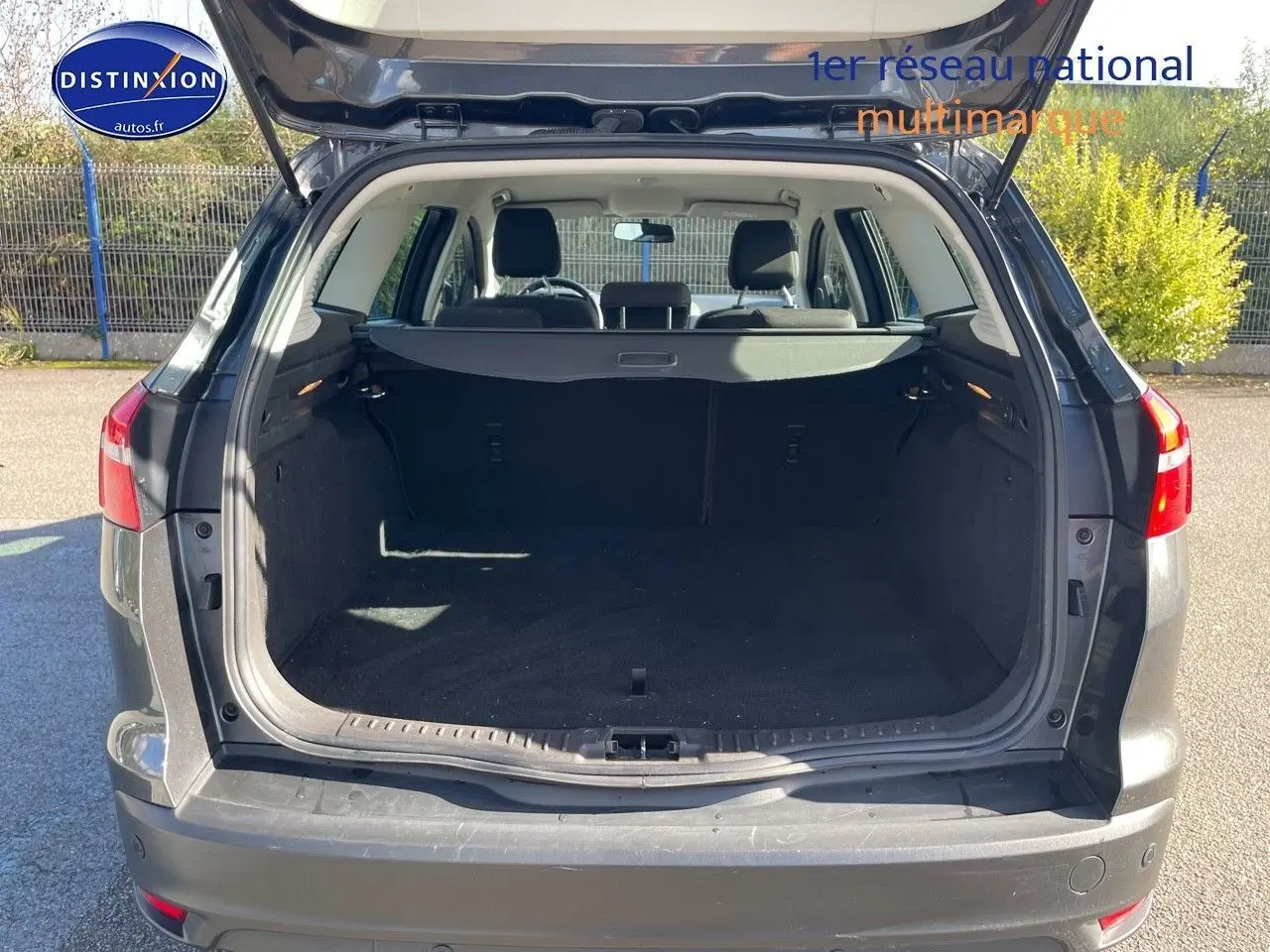 Vue arrière ouverte sur le coffre spacieux d'une Ford Focus SW 2018 gris magnetic metal, avec intérieur noir visible.