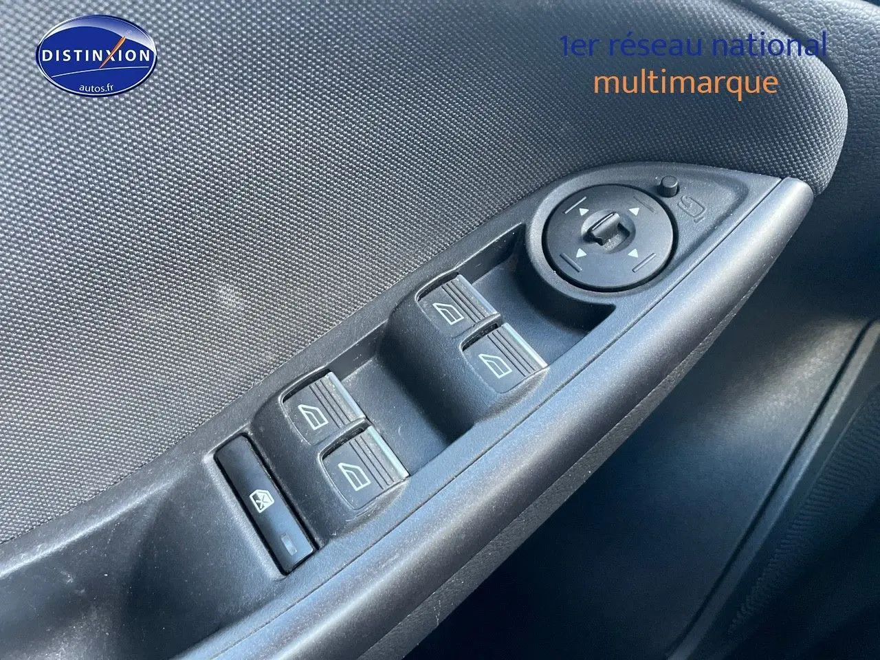 Gros plan sur les commandes des vitres électriques et rétroviseurs côté conducteur d'une Ford Focus SW gris magnetic de 2018.