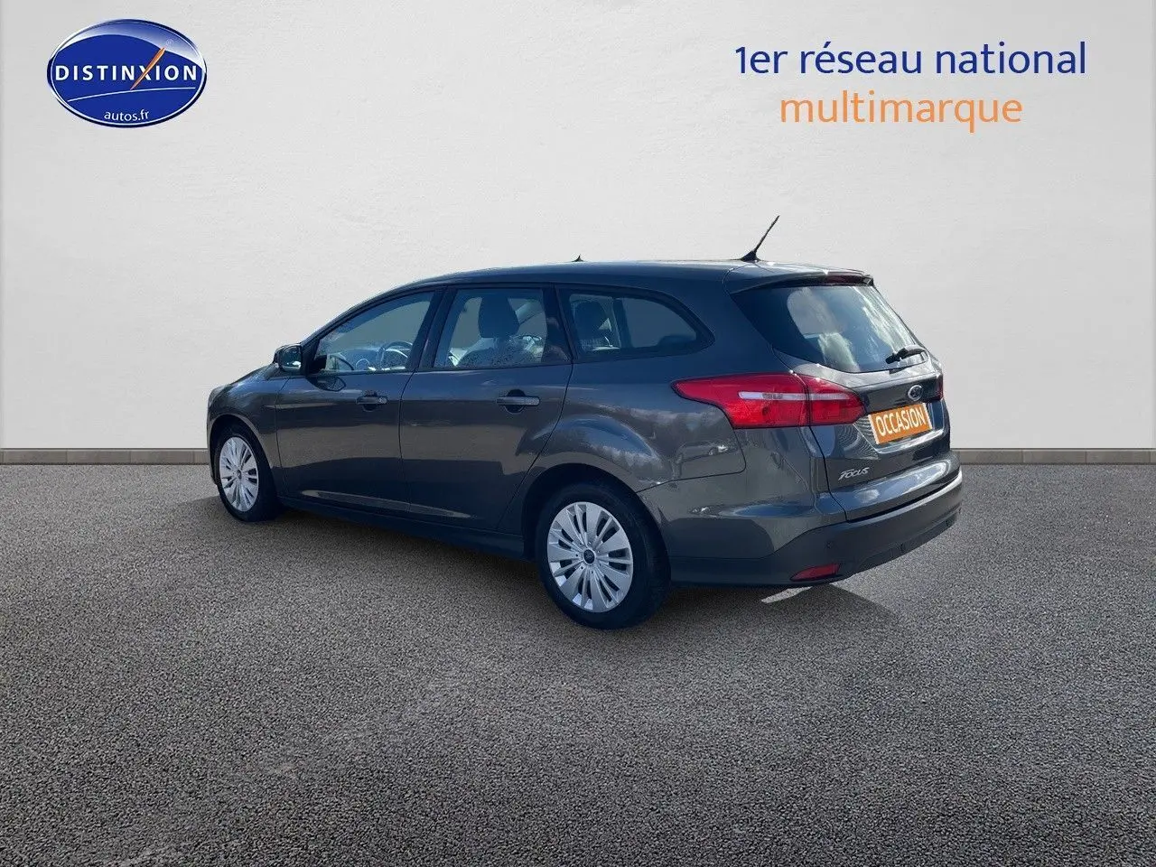 Ford Focus SW gris magnetic metal vue 3/4 arrière côté droit, avec plaques occasion et hayon fermé.