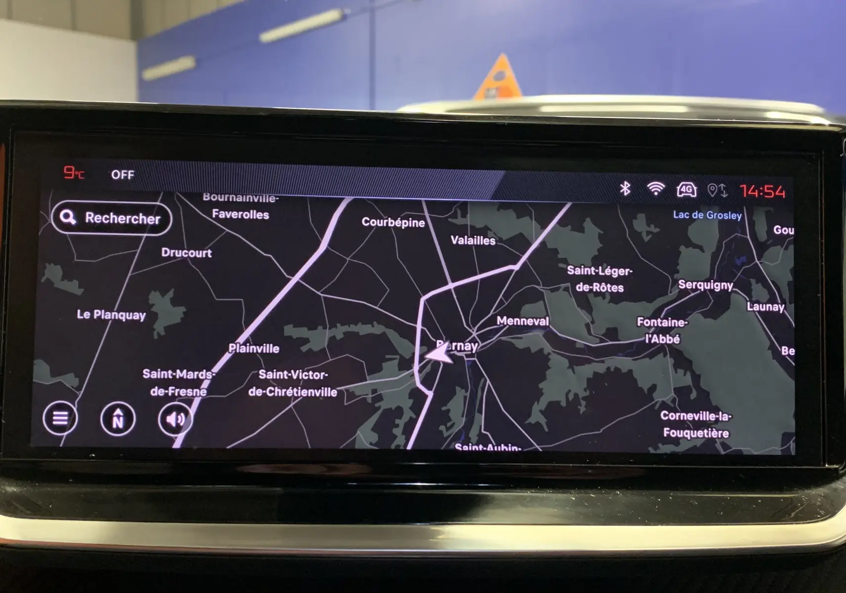 Écran de navigation GPS allumé dans le tableau de bord d'une Peugeot 2008 gris 2023, affichant une carte routière détaillée.