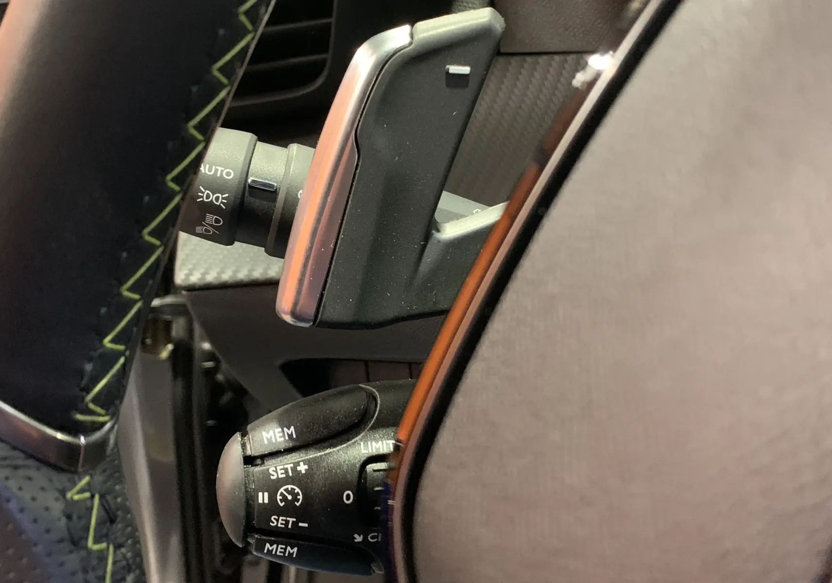 Gros plan sur la commande de régulateur de vitesse au volant du Peugeot 2008 gris 2023, finition GT.