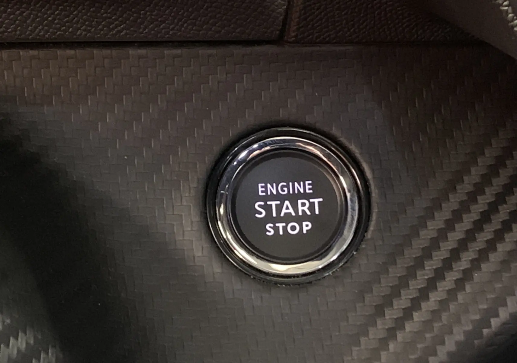 Bouton start/stop moteur sur tableau de bord en carbone du Peugeot 2008 BlueHDi 130 GT gris 2023.
