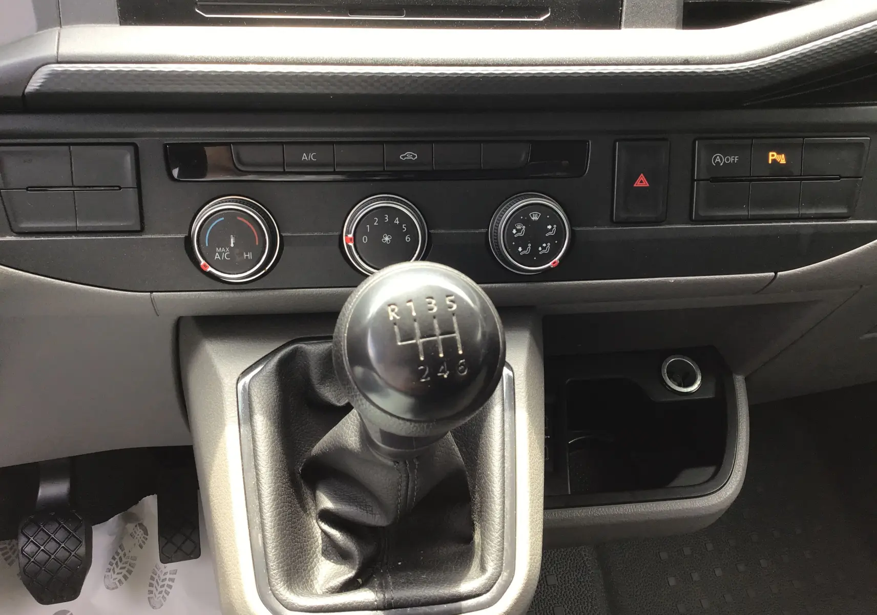 Gros plan sur le levier de vitesses manuel et la console centrale noire du Volkswagen Transporter 6.1 blanc de 2020.