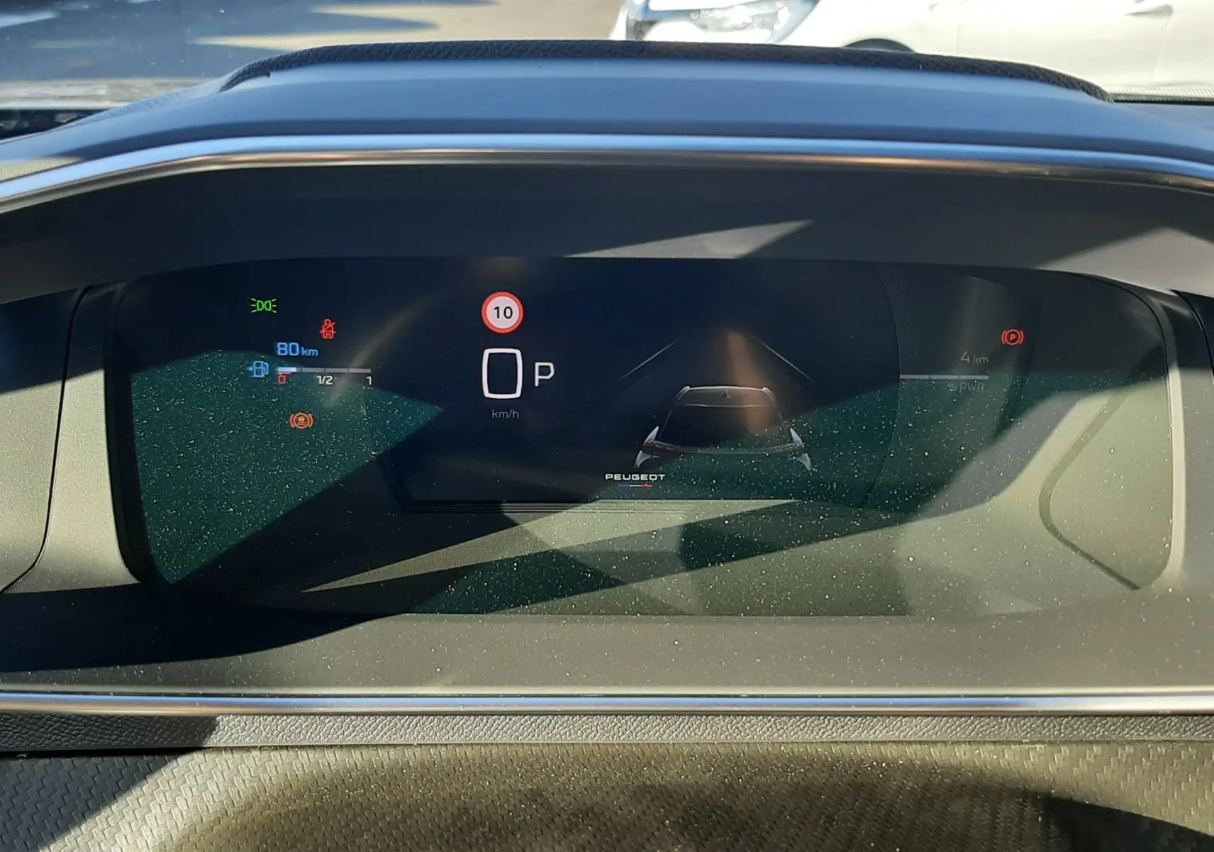 Affichage numérique du tableau de bord du Peugeot 2008 gris Selenium, montrant la vitesse à 0 km/h et le mode parking.