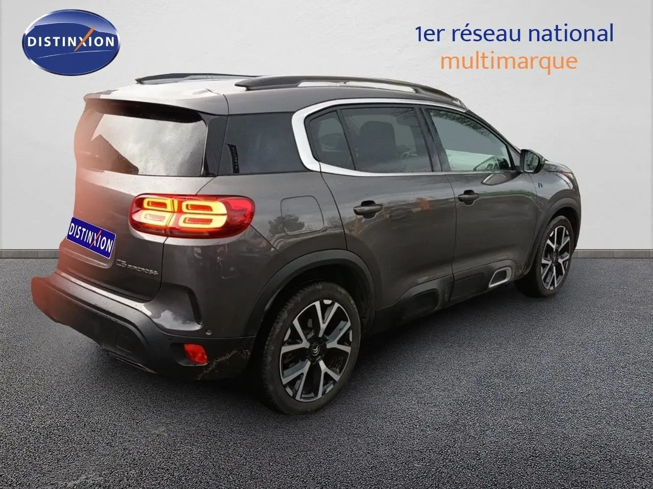 Vue 3/4 arrière droite du Citroën C5 Aircross hybride rechargeable 2022 en gris platinium avec jantes distinctives.