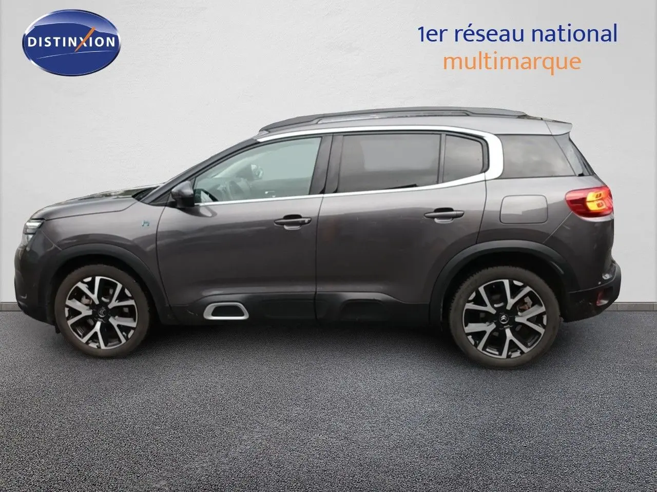 Vue latérale droite d'un Citroën C5 Aircross hybride rechargeable 2022 gris platinium avec jantes noires et détails chromés.