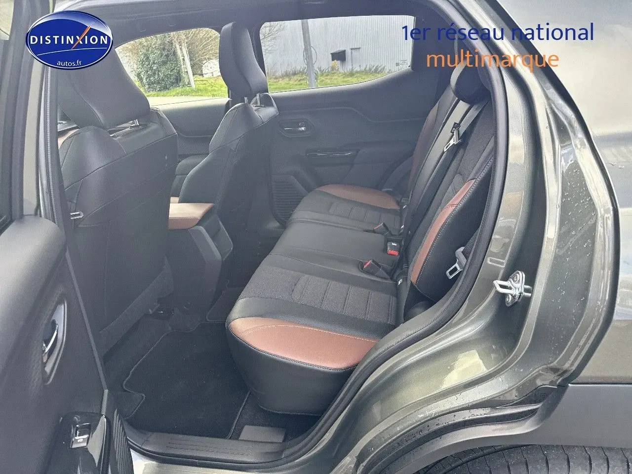Vue côté gauche arrière du Suzuki Vitara 2026 vert Land Breeze avec intérieur cuir noir et marron visible.