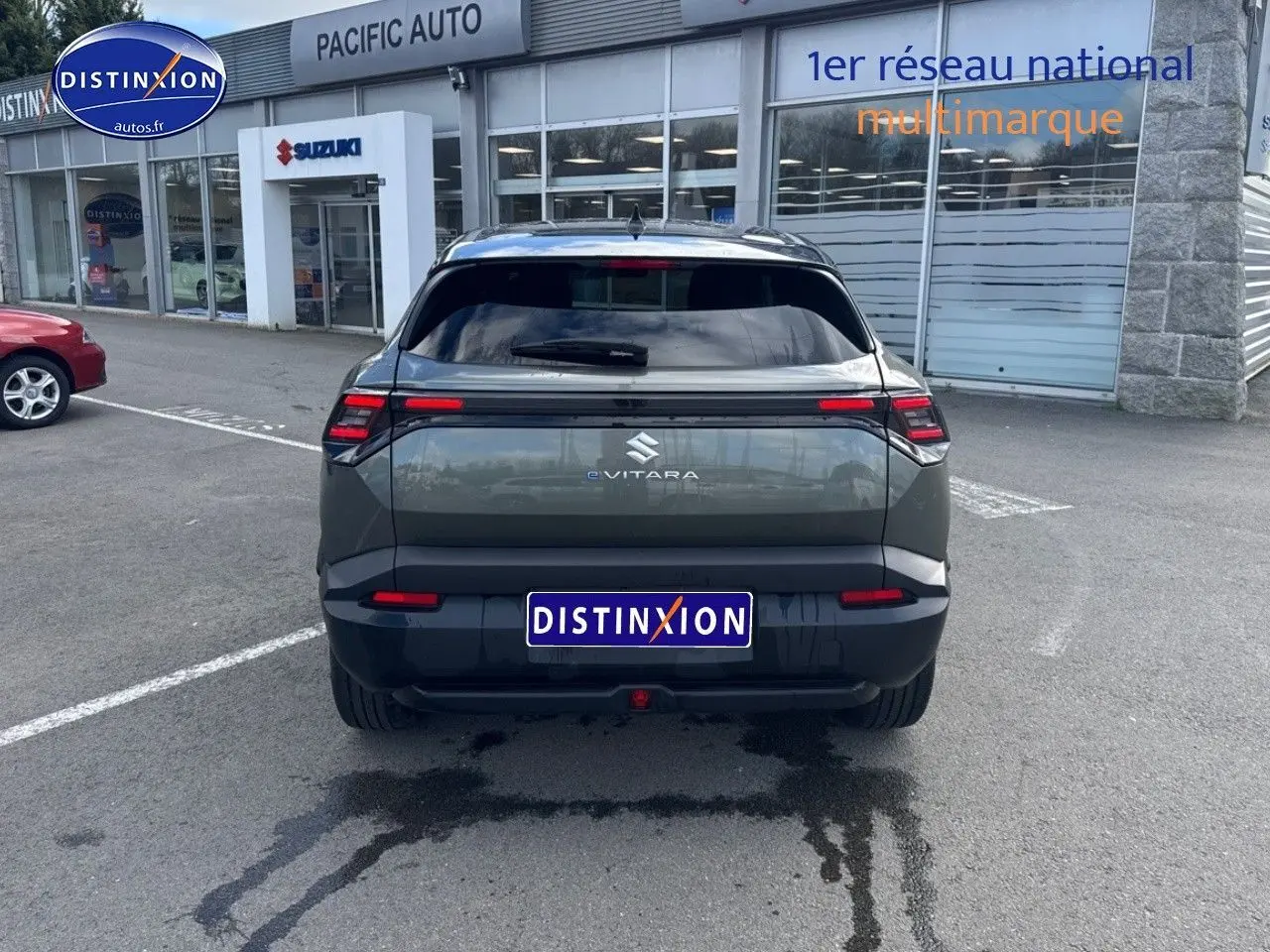 Vue arrière d'un Suzuki Vitara électrique 2026 en vert Land Breeze avec toit noir, feux arrière LED et logo eVITARA.