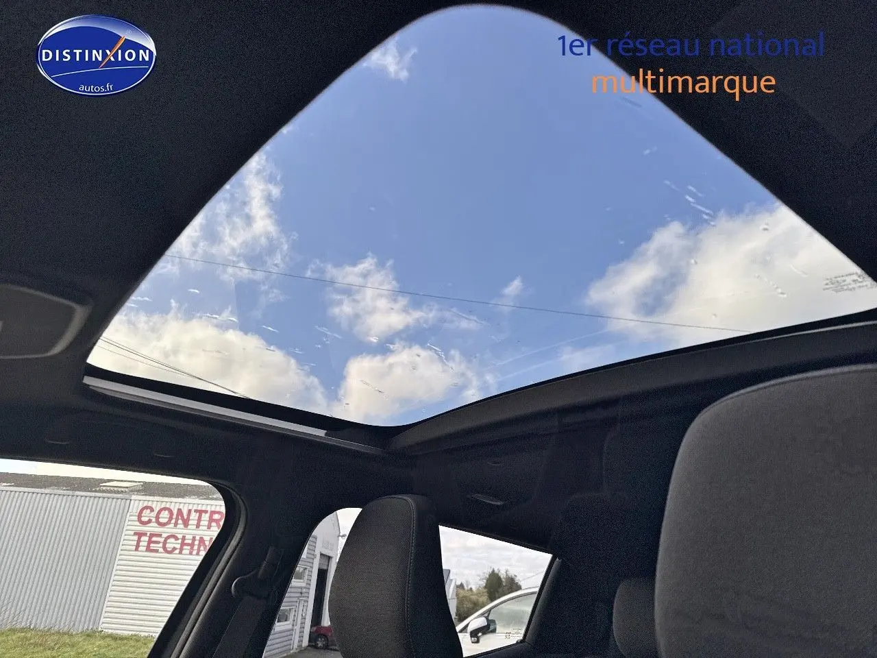 Vue intérieure du toit panoramique en verre du Suzuki Vitara 2026, avec ciel bleu visible à travers la vitre ouverte.