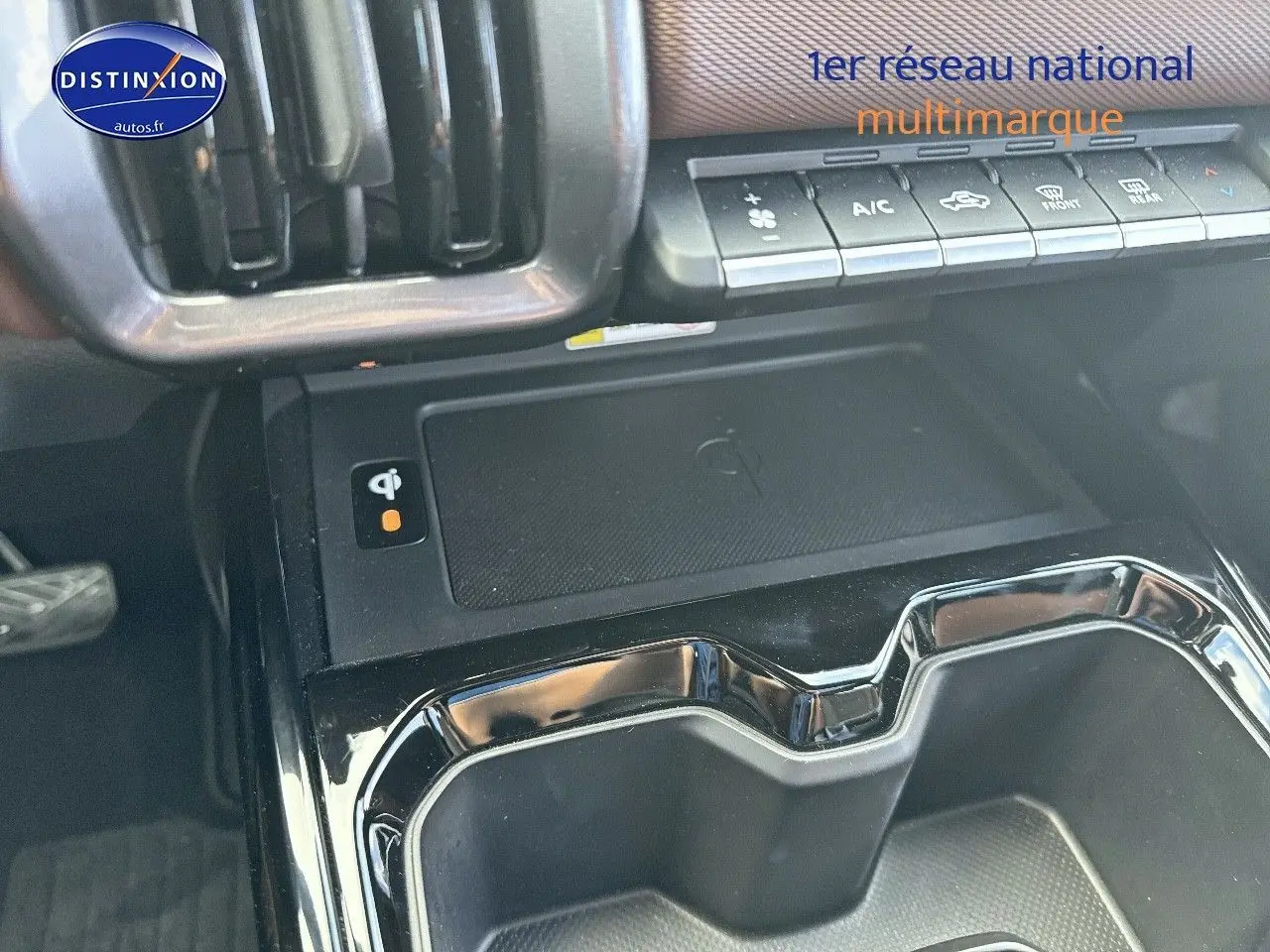 Gros plan sur la console centrale du Suzuki Vitara 2026 avec chargeur sans fil et commandes climatisation.
