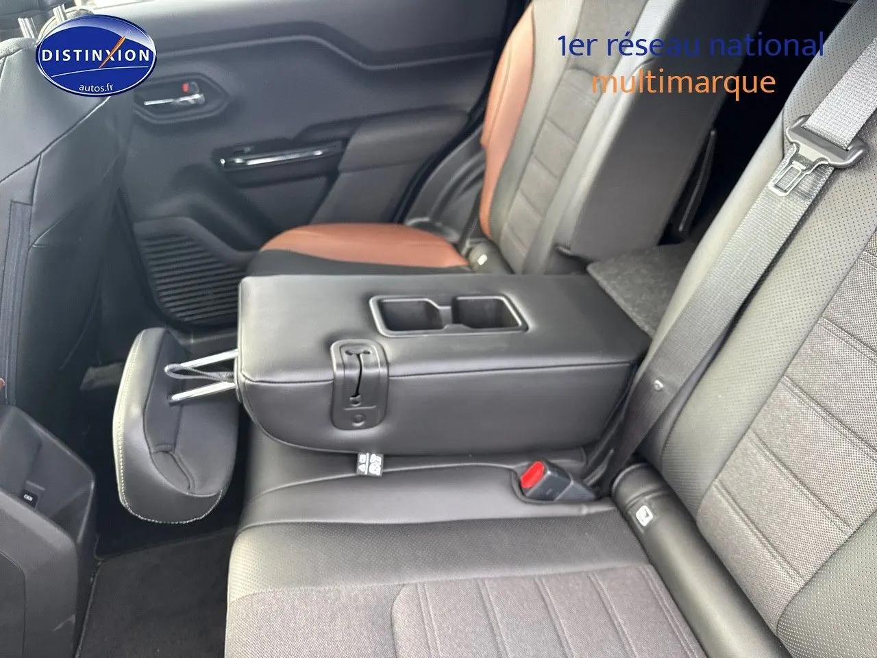 Vue intérieure arrière du Suzuki Vitara 2026, montrant la banquette bicolore noire et marron avec accoudoir central relevé.