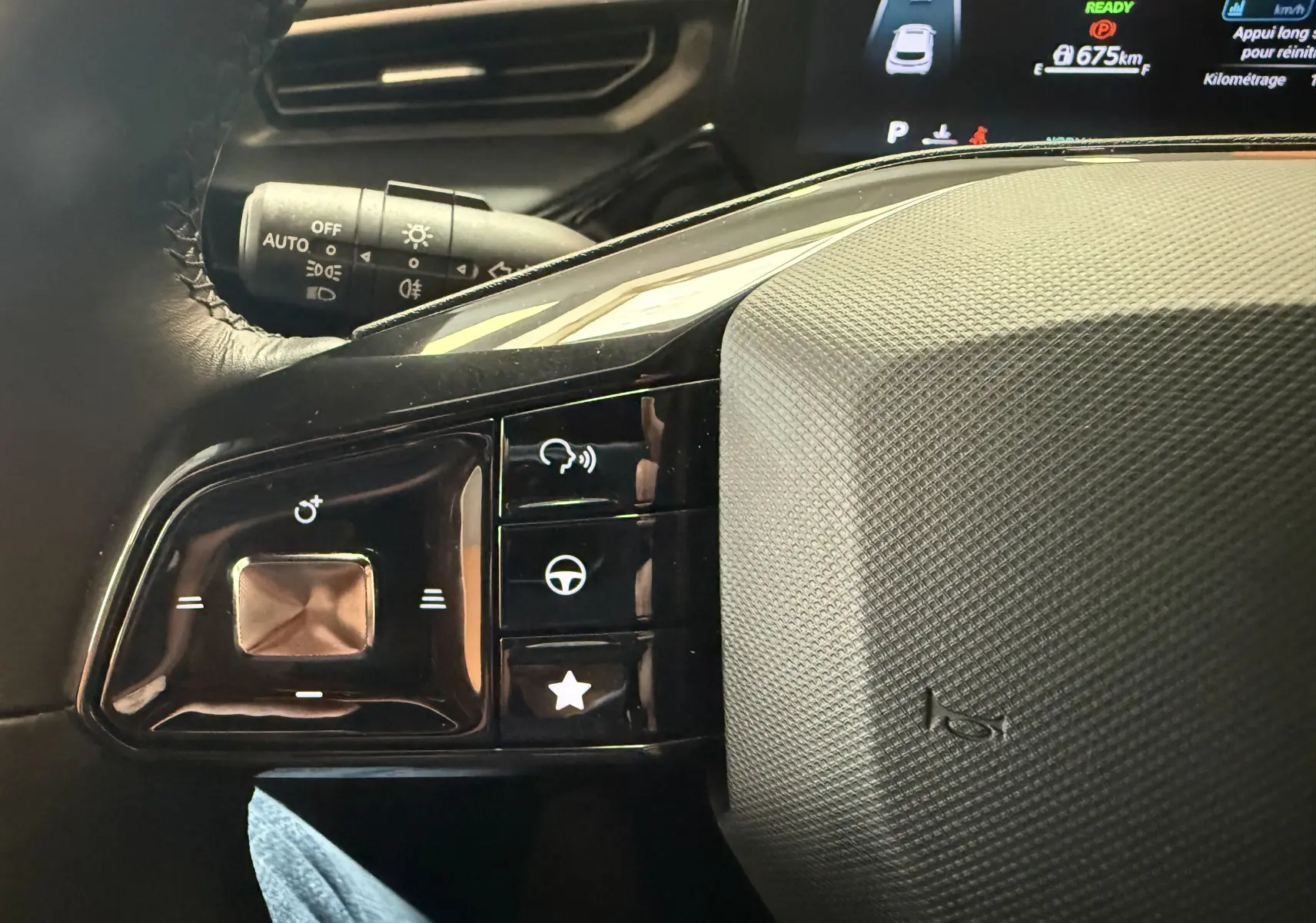 Gros plan sur les commandes multifonctions à gauche du volant noir du MG3 1.5 L Hybrid+ Luxury, avec écran digital en arrière-plan.
