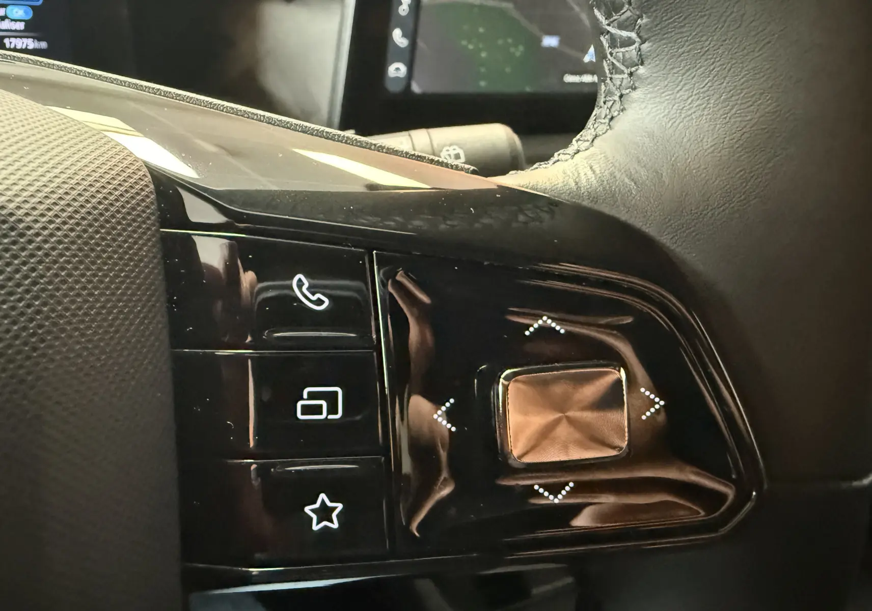 Gros plan sur les commandes noires du volant côté gauche du MG3 Luxury, avec boutons tactiles et finition brillante.