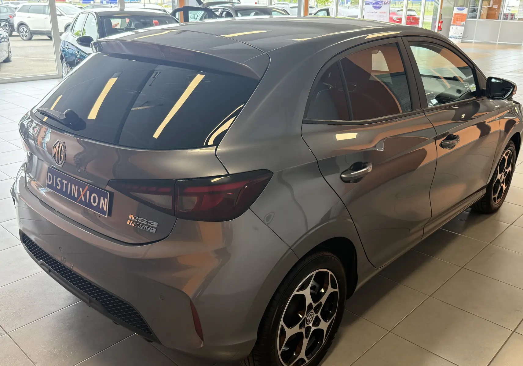 Vue 3/4 arrière droite de la MG3 Hybrid+ Hampstead Grey en intérieur, avec vitres surteintées et jantes bi-ton distinctives.