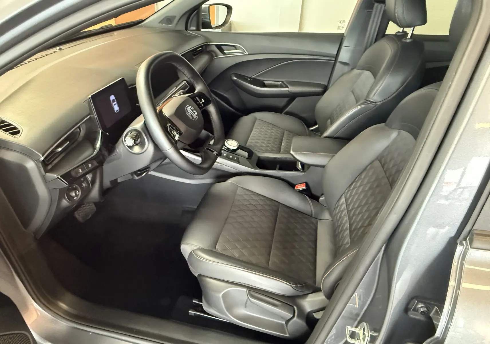 Intérieur noir de la MG3 1.5 L Hybrid+ Luxury vu côté conducteur, avec sièges en similicuir et écran tactile central.