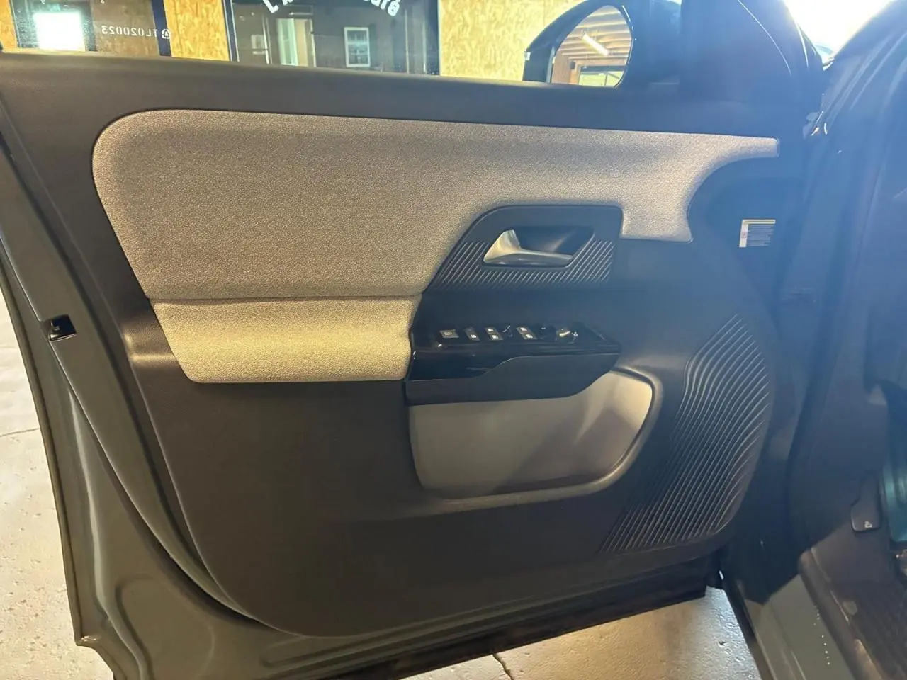 Intérieur de la porte avant gauche du Citroën C5 Aircross 2026 vert, avec commandes de vitres et poignée intégrée.