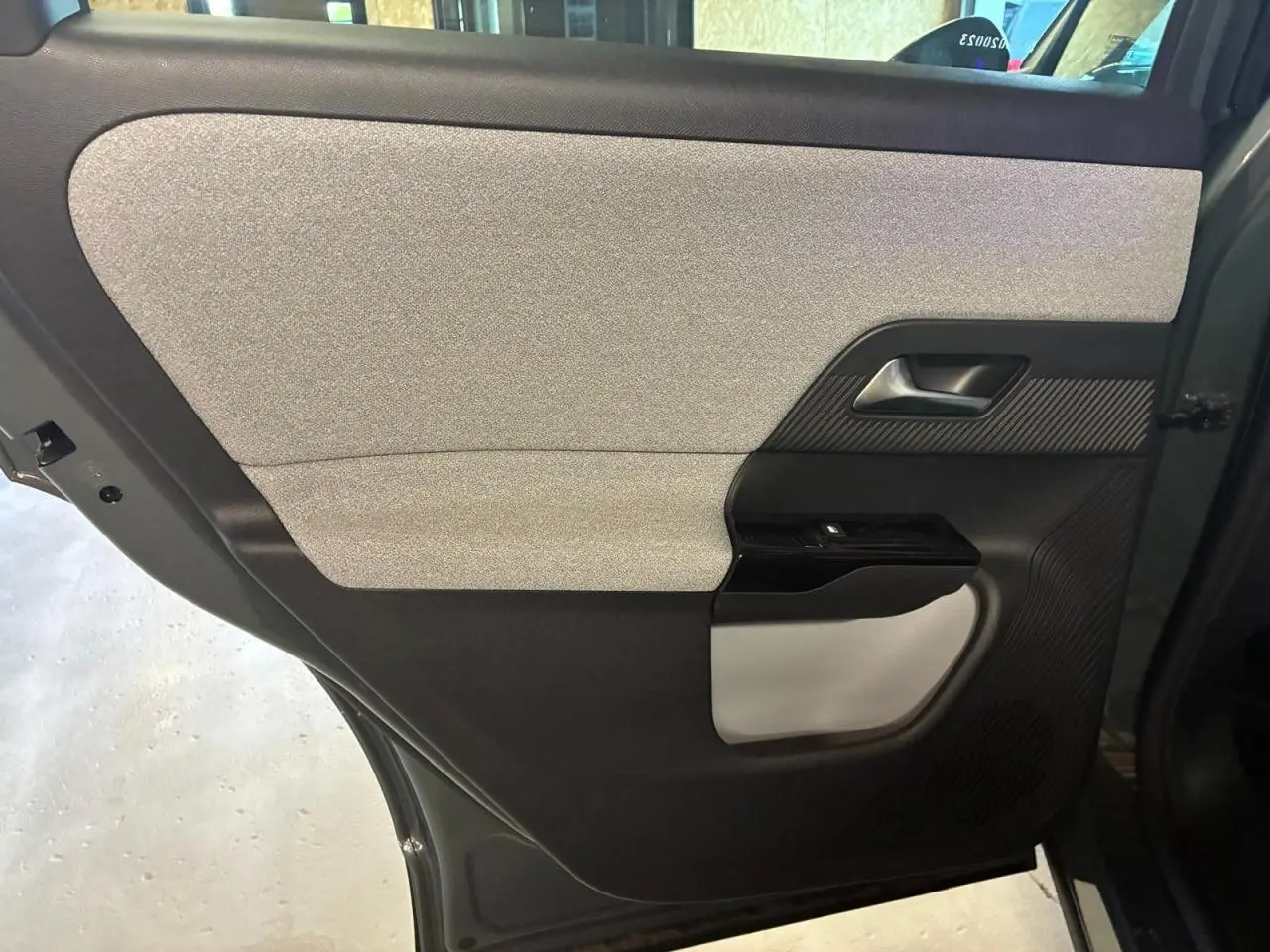 Détail de la porte arrière gauche du Citroën C5 Aircross vert 2026, avec garniture grise et noire et poignée intégrée.