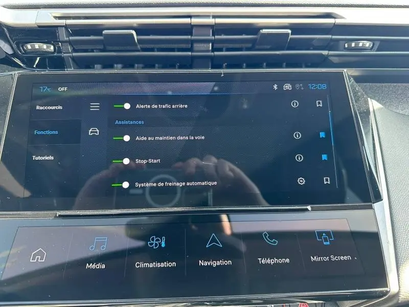 Écran tactile central affichant les aides à la conduite dans l’habitacle d’une Peugeot 308 bleu, vue de face.
