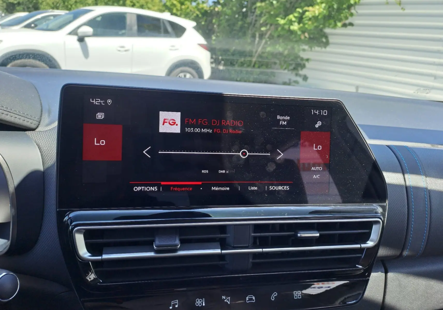Écran tactile central du tableau de bord du Citroën C5 Aircross gris artense, affichant la radio FM et la climatisation en mode automatique.