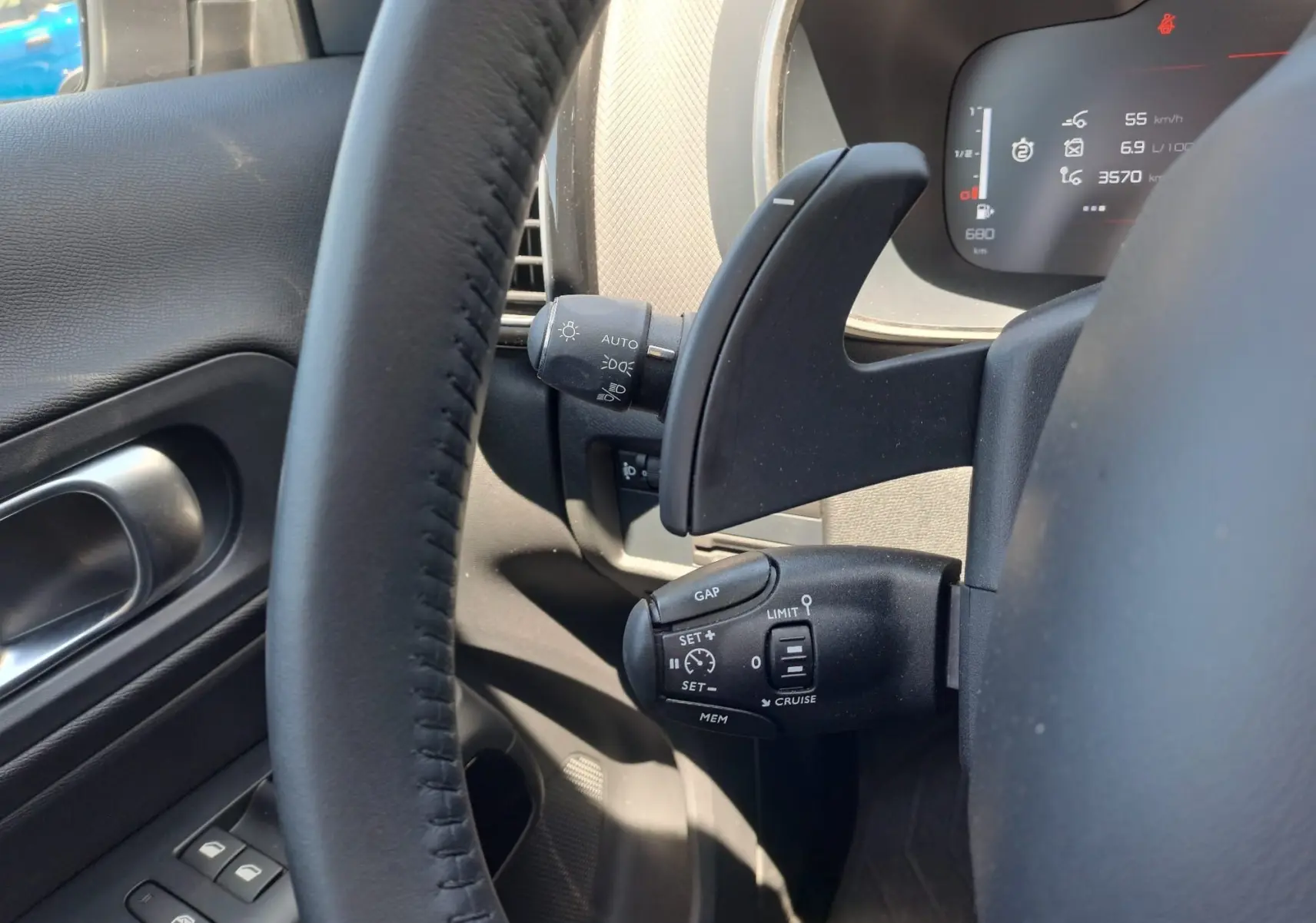 Vue rapprochée du volant côté gauche du Citroën C5 Aircross gris, montrant commandes de régulateur et tableau de bord digital.