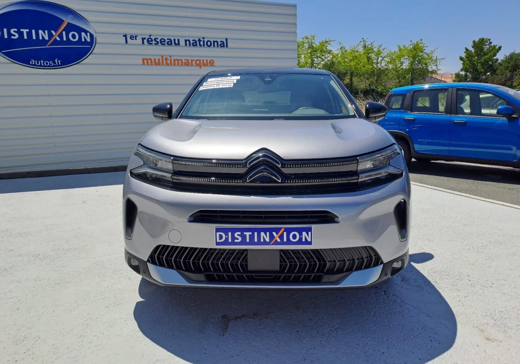Vue frontale d'un Citroën C5 Aircross gris Artense avec toit noir, calandre distinctive et logo chromé visible.