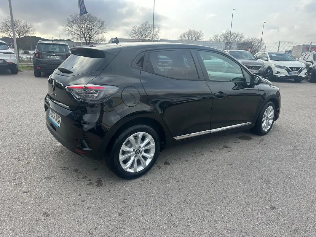 Renault Clio V dCi 100 Evolution noire vue en 3/4 arrière droit avec vitres surteintées et jantes argentées.