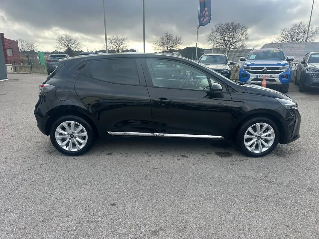 Profil droit d'une Renault Clio noire 2025 avec vitres surteintées et jantes alliage visibles en extérieur.