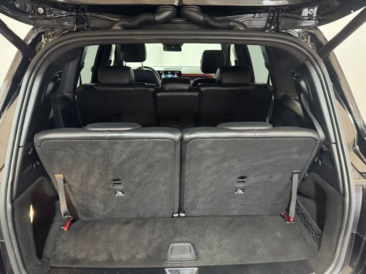 Vue arrière ouverte du coffre du Mercedes GLB 200 d AMG Line noir, montrant la 3ème rangée de sièges individuels rabattus.