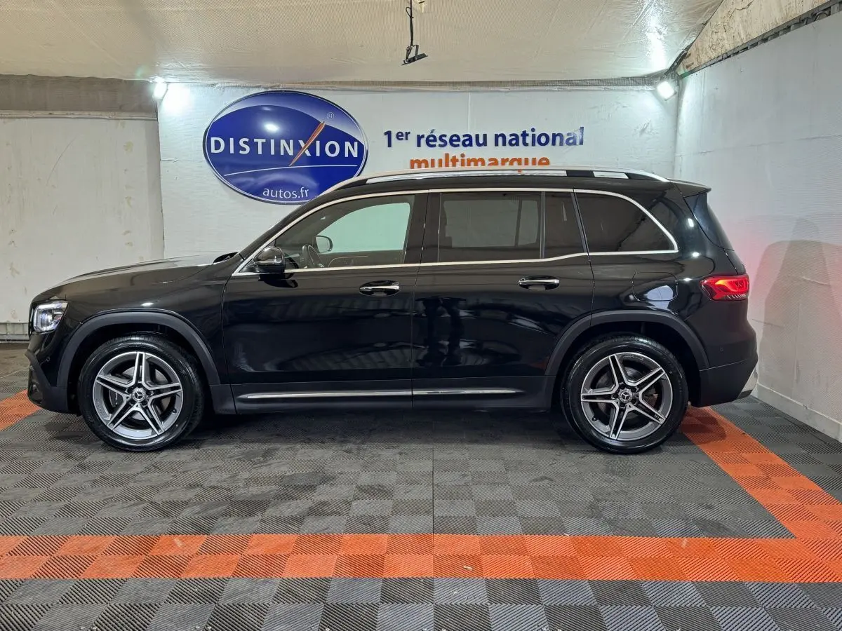 Vue de profil côté gauche d’un Mercedes GLB 200 d AMG Line noir avec jantes alliage et rails de toit chromés.