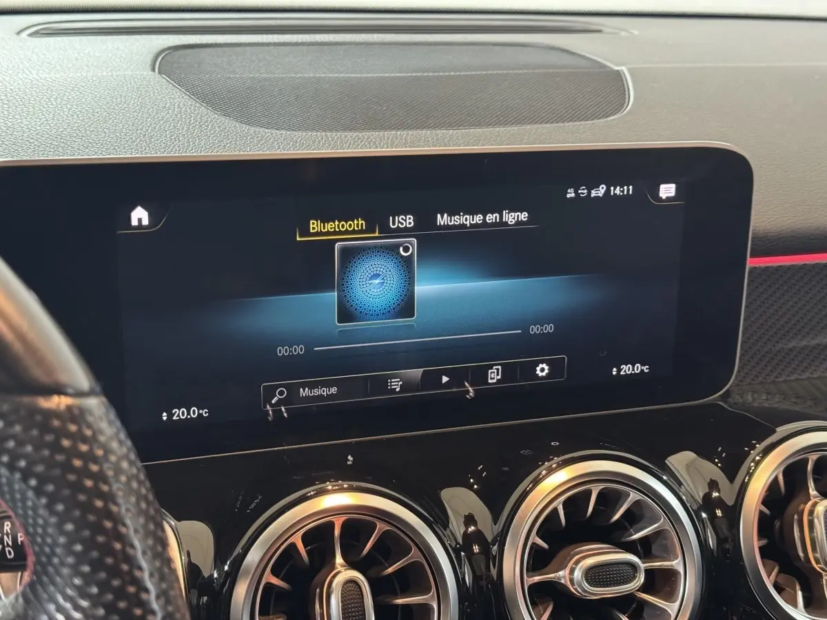 Vue rapprochée de l’écran tactile multimédia et des aérateurs ronds noirs du tableau de bord d’un Mercedes GLB 200 d AMG Line.