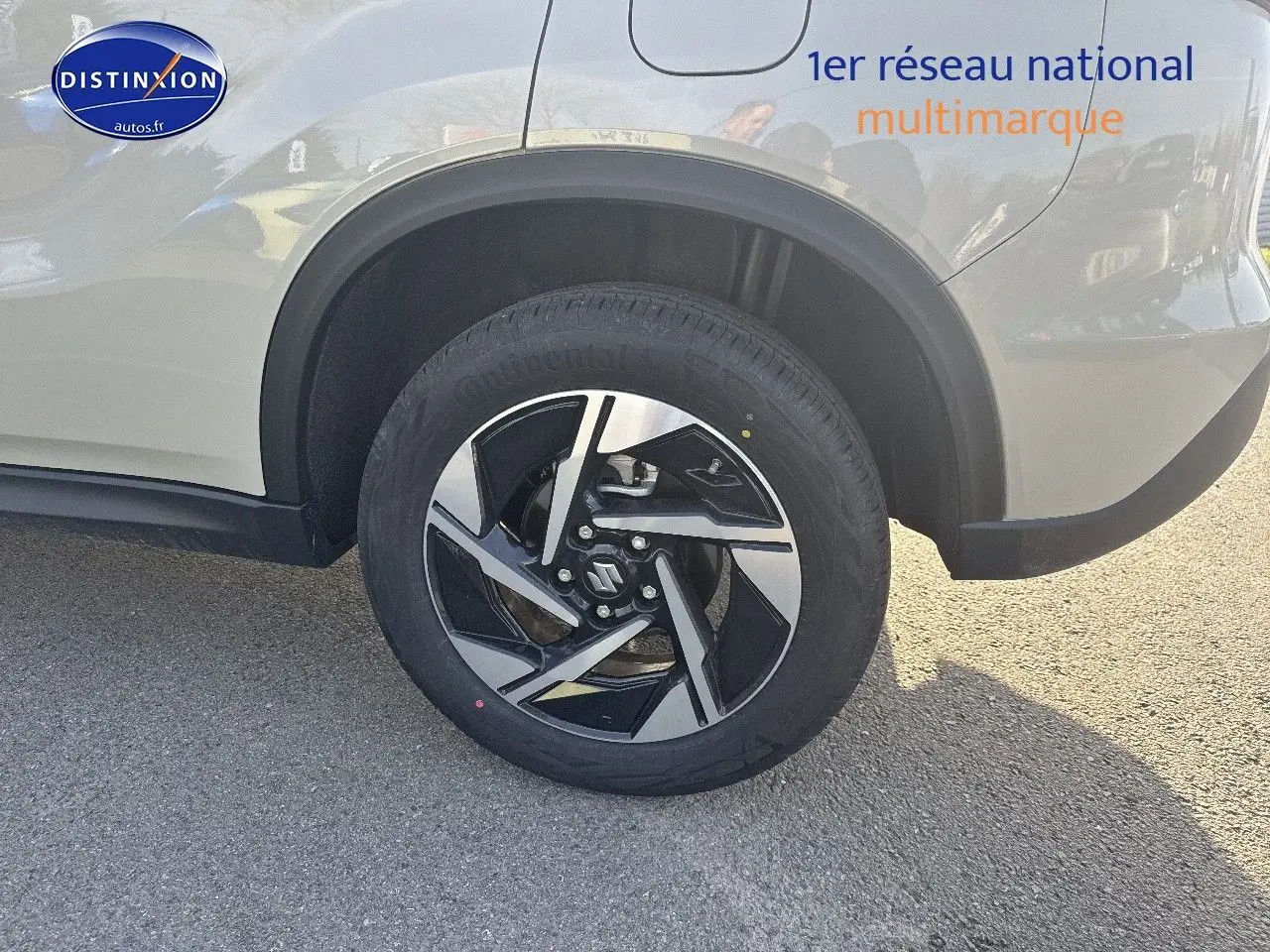 Gros plan sur la roue arrière droite d’un Suzuki Vitara ivoire So'Color avec jante alu bicolore noire et argent.