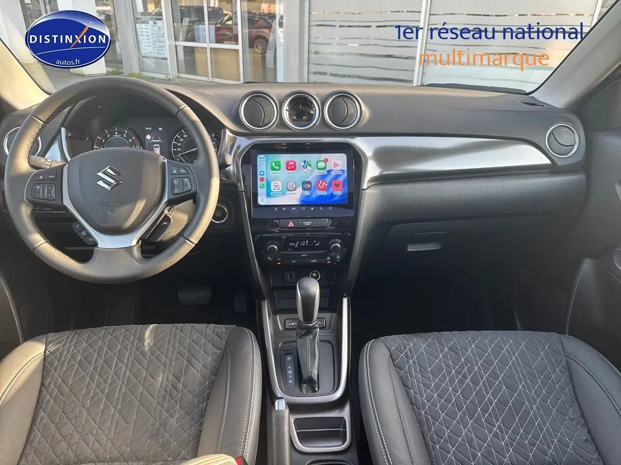 Vue intérieure avant du Suzuki Vitara 1.4 Boosterjet Hybrid, volant multifonction, écran tactile et sièges en suédine noire.