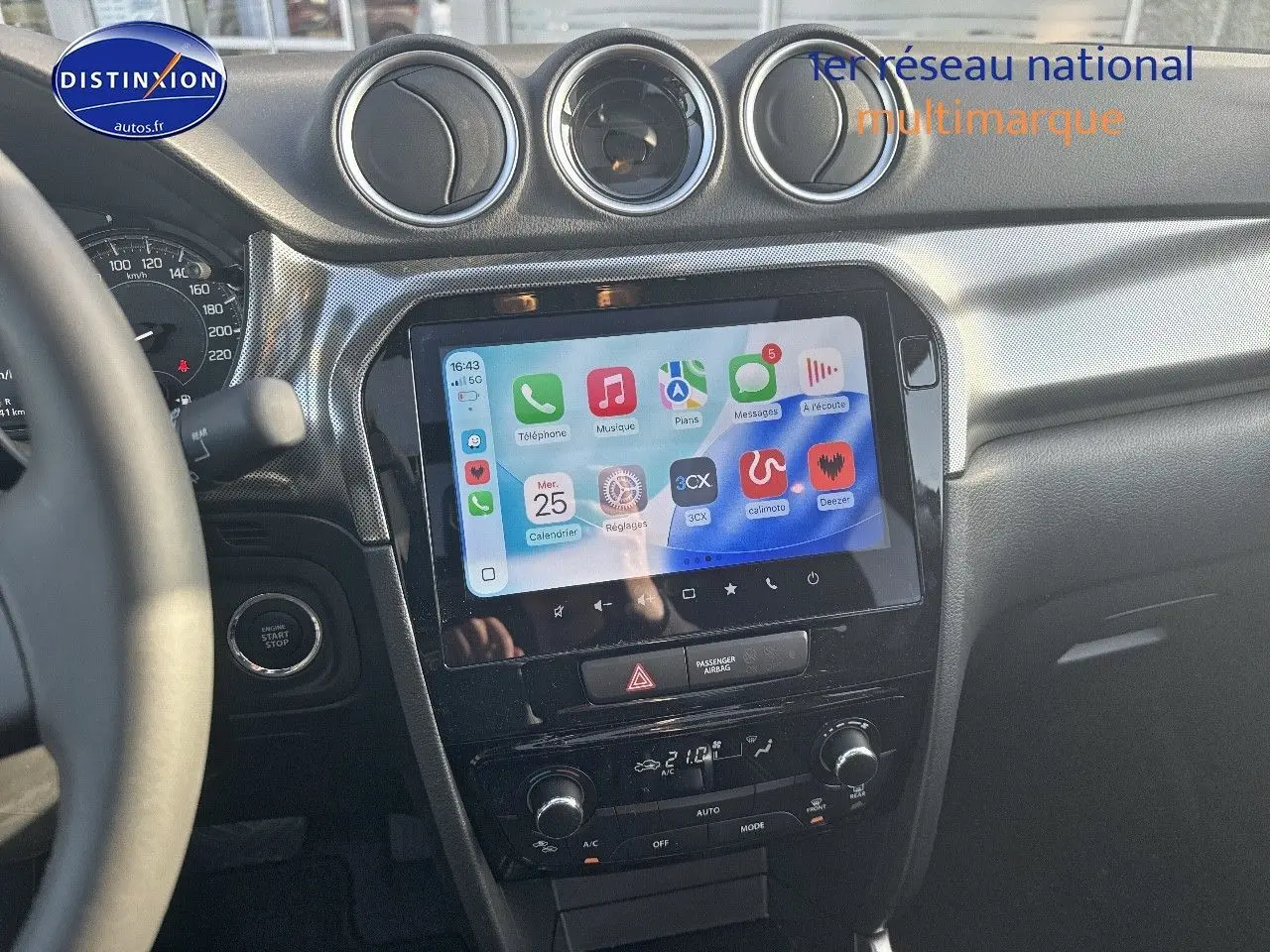 Vue intérieure du tableau de bord du Suzuki Vitara 1.4 Boosterjet Hybrid avec écran tactile et commandes climatisation.