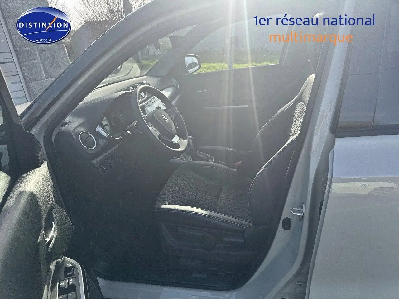 Intérieur côté conducteur du Suzuki Vitara 2026 en So'Color Savanna Ivory, sièges cuir noir et volant multifonction.